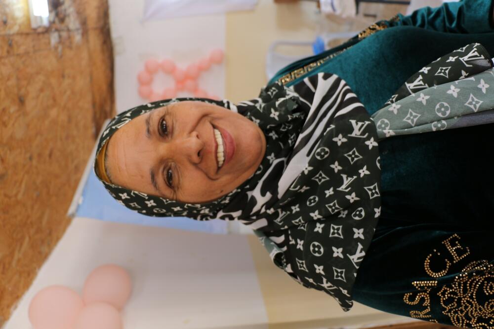 Khawla, 50, smiles at the camera while standing in the mobile clinic in the West Bank's Al Uqban.