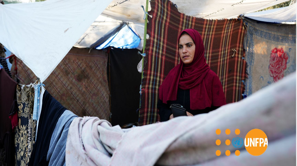 A woman in Gaza standing outside her tent in one of the shelters
