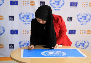 Palestinian youth signing MUN flag