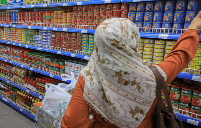 A woman benefitting from cash voucher assistance in one of the stores in Palestine