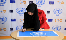 Palestinian youth signing MUN flag