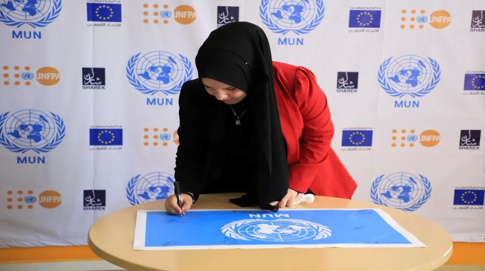Palestinian youth signing MUN flag