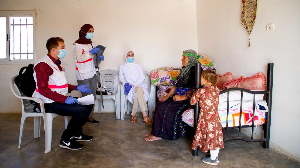 Old woman receiving services at a mobile clinic in West Bank